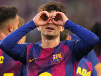Joueur de football mime des jumelles avec ses mains.