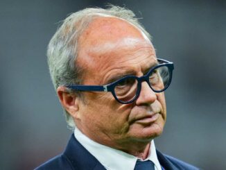 Homme avec lunettes et costume sombre.