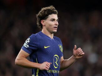 Joueur de football en maillot bleu au match.