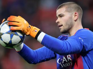 Gardien de but tenant un ballon de football.