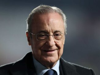 Homme avec lunettes et cheveux gris souriant.