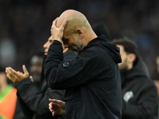 Homme en noir, tête baissée, main sur le front.