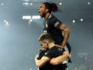 Joueurs de football célébrant un but sur le terrain.