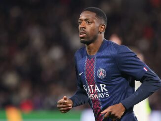 Joueur de football sur le terrain en maillot bleu.