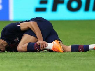 Footballeur blessé allongé sur le terrain.
