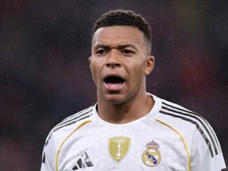Joueur de football avec maillot blanc sur le terrain.