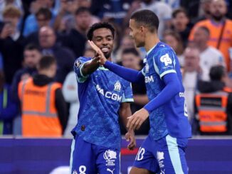 Joueurs de football célébrant un but sur le terrain.