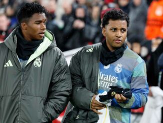 Deux joueurs de football discutant en manteaux.