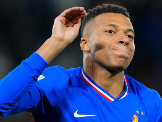 Joueur de football en maillot bleu célébrant.