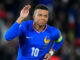 Footballeur en maillot bleu saluant le public