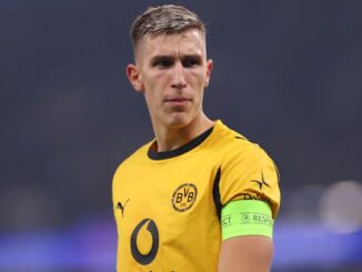 Footballeur en maillot jaune sur le terrain.