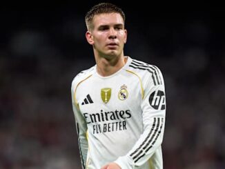 Joueur de football en maillot blanc sur le terrain.