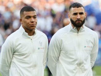 Deux joueurs de football en survêtement blanc.
