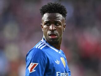 Joueur de football en maillot bleu sur le terrain.