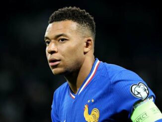 Joueur de football en action, maillot bleu.