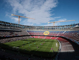 Stade de football en construction avec spectateurs.