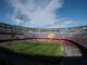 Stade de football en construction avec spectateurs.
