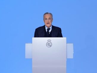 Homme parlant derrière un pupitre avec logo.