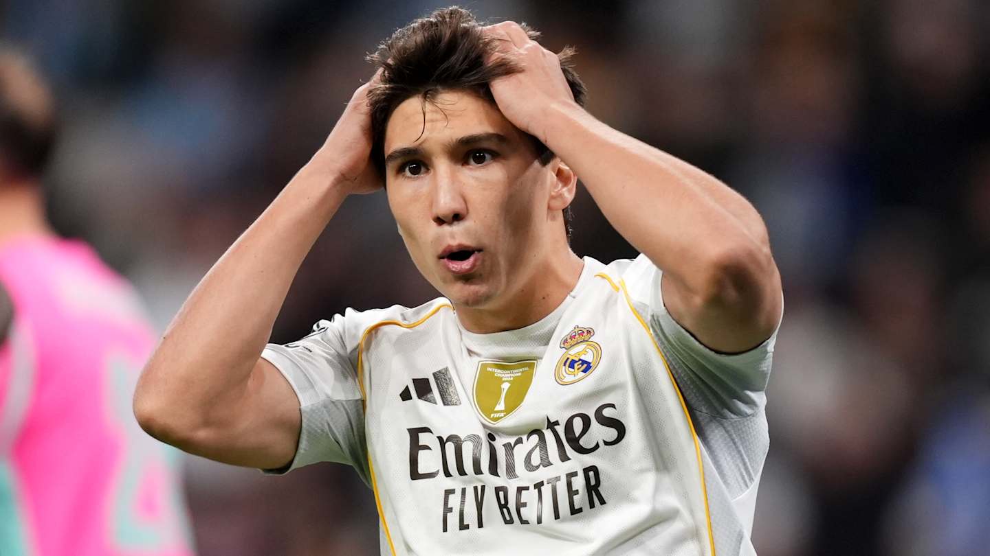 Footballeur en maillot blanc surpris sur le terrain.