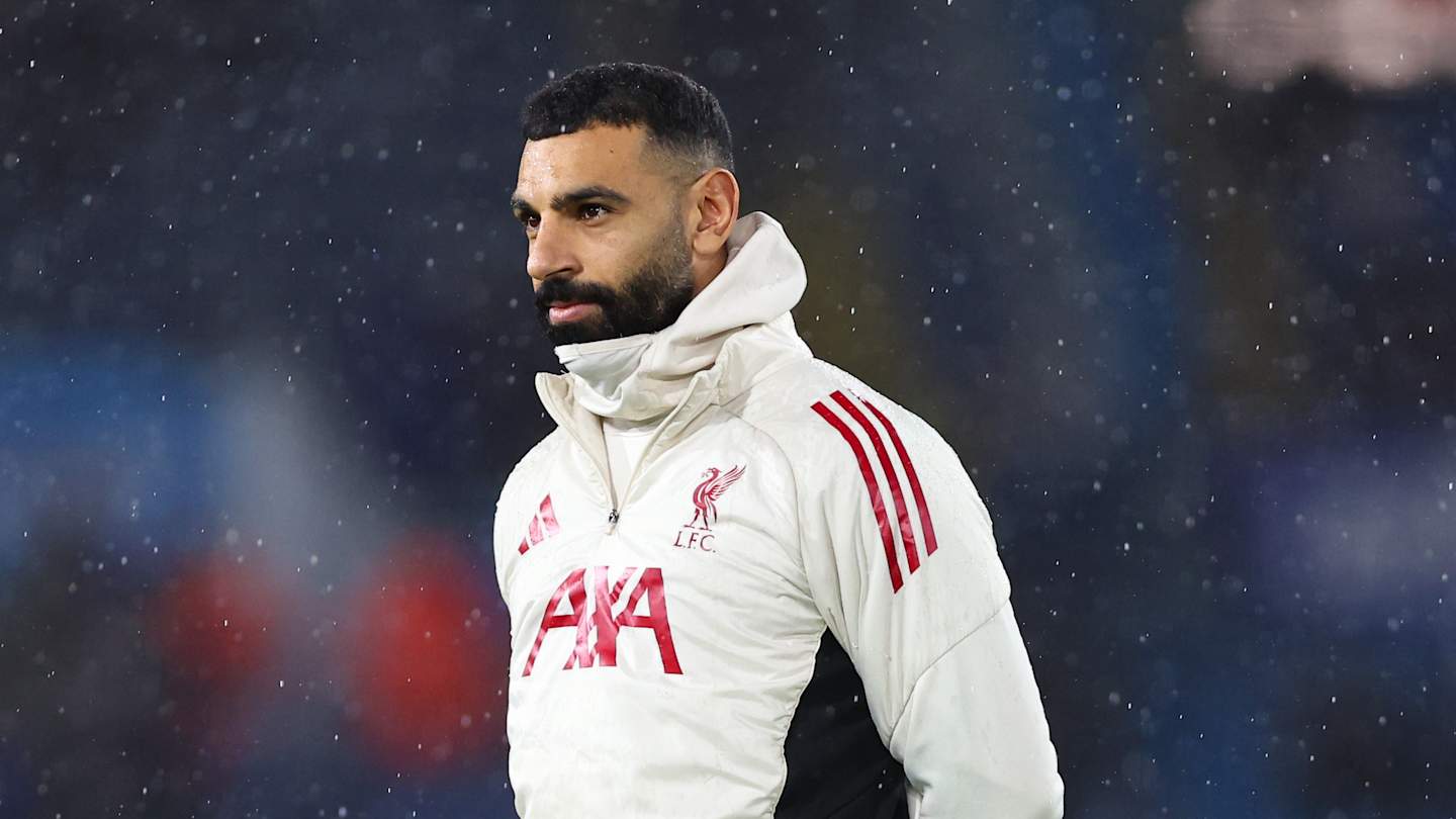 Joueur de football sous la neige avec veste blanche.