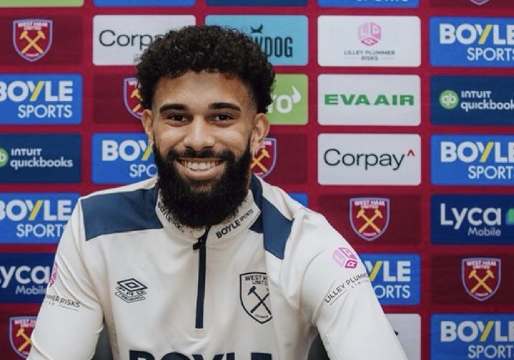 Joueur de football souriant avec maillot blanc.