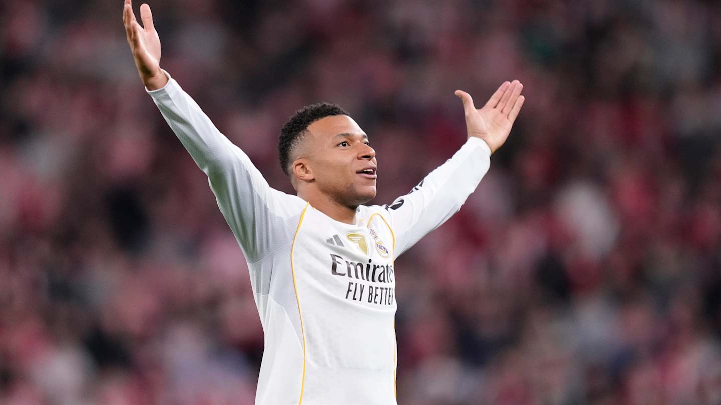 Footballeur en maillot blanc levant les bras