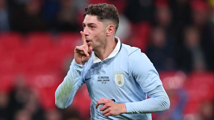 Footballeur en maillot bleu faisant un geste silence