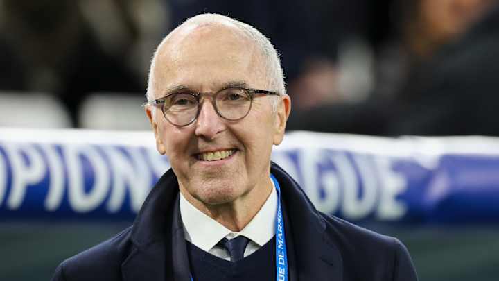 Homme âgé souriant avec lunettes dans un stade