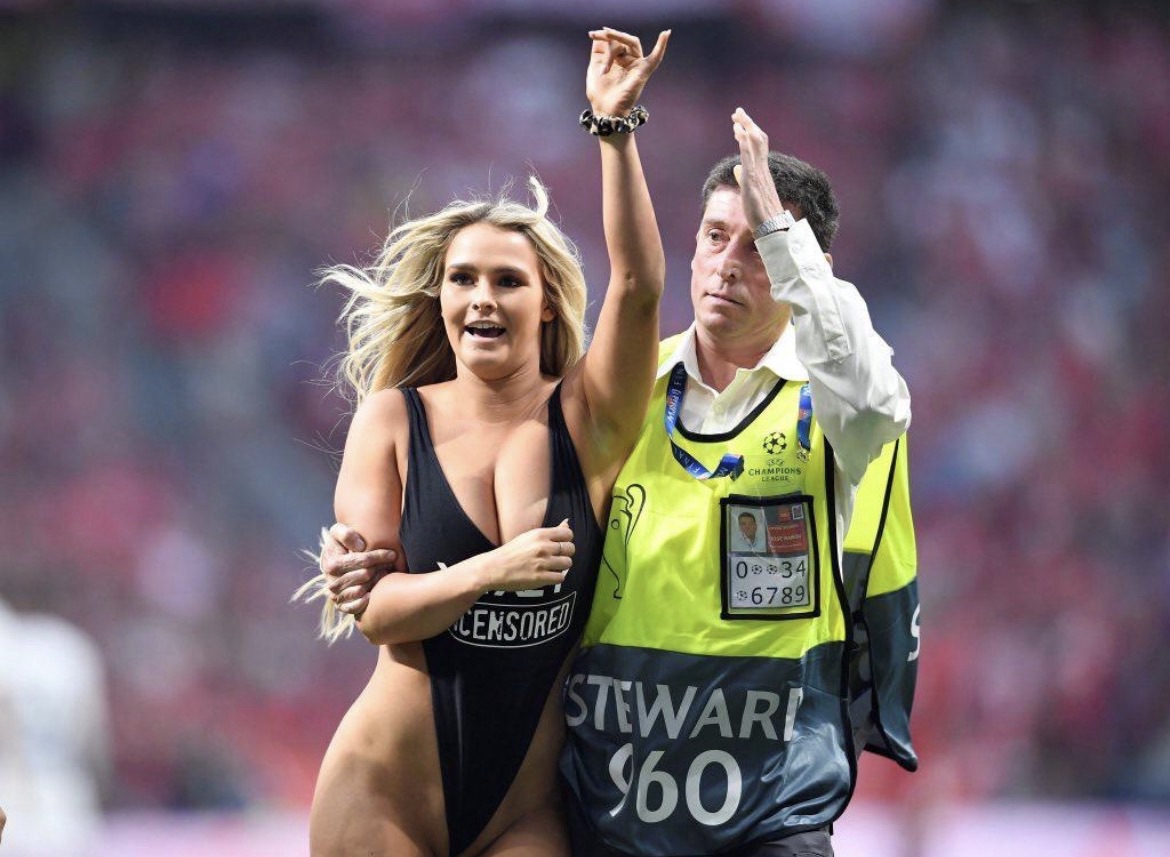 Femme en maillot noir escortée par un steward