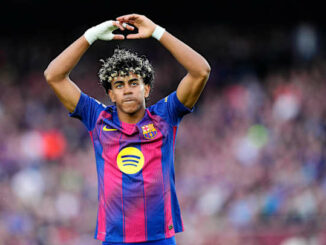 Footballeur en maillot blaugrana bras levés au stade