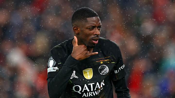 Footballeur en maillot noir faisant geste téléphone