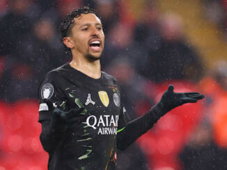 Footballeur en maillot noir sous la pluie