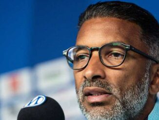 Homme barbu parlant lors d’une conférence de presse