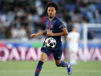 Footballeur en maillot bleu courant avec ballon