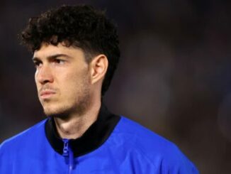 Joueur de football en veste bleue au stade