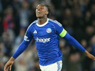 Footballeur en maillot bleu célébrant un but