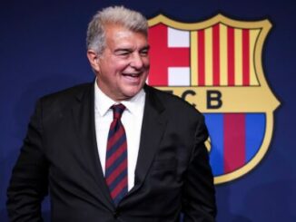 Homme en costume devant logo du FC Barcelone