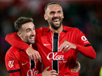 Deux footballeurs en rouge célèbrent un but