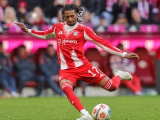 Footballeur en rouge frappant le ballon