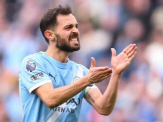 Footballeur en maillot bleu applaudit sur le terrain