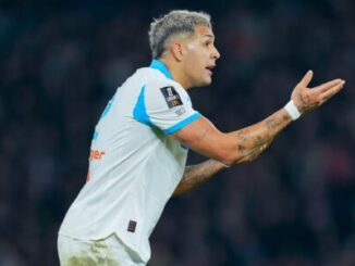 Footballeur en maillot blanc gesticulant sur le terrain