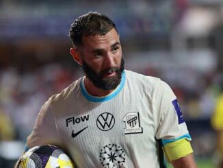 Footballeur barbu tenant un ballon sur le terrain