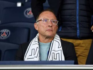 Homme assis en tribune avec écharpe PSG