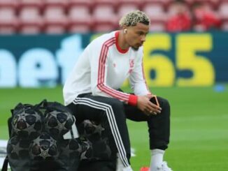 Footballeur assis sur sacs d’entraînement au stade