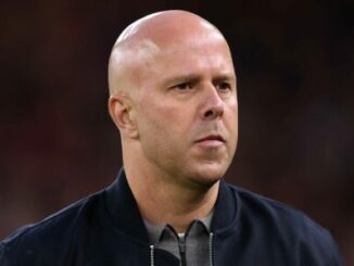 Homme chauve au regard sérieux en veste sombre