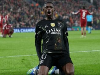 Footballeur en noir célèbre en glissant sur genoux
