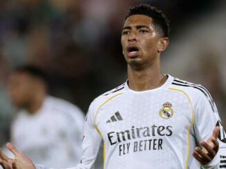 Joueur de football en maillot blanc bras écartés