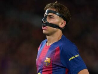 Footballeur du FC Barcelone portant un masque noir