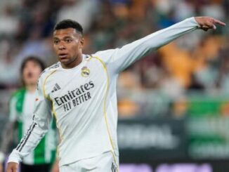 Footballeur en maillot blanc pointant du doigt