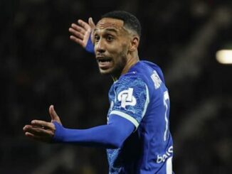 Footballeur en maillot bleu gesticulant sur le terrain